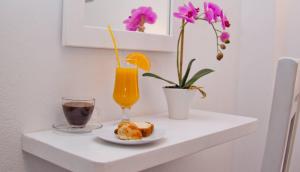 una mesa con un vaso de zumo de naranja y un plato de comida en Nemesis, en Fira