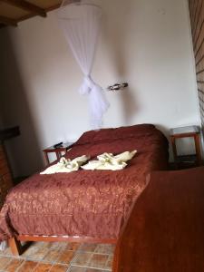 a bedroom with a bed with a red comforter at Hostal Naylamp in Huanchaco