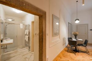 La salle de bains est pourvue d'une table, de chaises et d'un lavabo. dans l'établissement Lazenska N4 Residence, à Prague 37 autres photos
