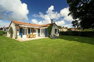 una pequeña casa blanca con un patio de césped en FranceComfort - L'Aveneau Vieille Vigne en Les Forges