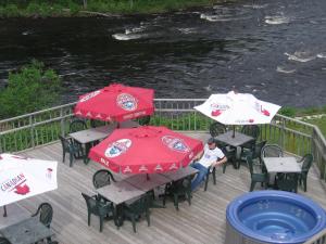 Petawawa River Inn & Suites في Petawawa: شخص يجلس على طاولة مع مظلات حمراء