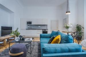 a living room with a blue couch and a table at Lazenska N4 Residence in Prague