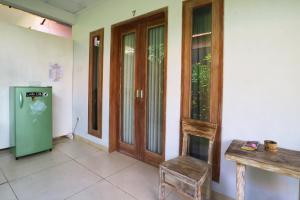 ein Raum mit einem Kühlschrank und einem Tisch und einem Stuhl in der Unterkunft The Wina Guest House 2 in Canggu + 33 Fotos
