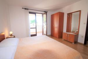 a bedroom with a large bed and a large mirror at Apartments Livio Stranici in Rošini