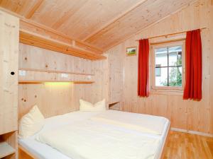 ein Schlafzimmer mit einem weißen Bett in einem Holzzimmer in der Unterkunft Chalet in Schwendau - A 241.003 in Schwendau