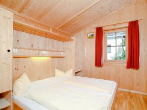 シュヴェンダウにあるChalet in Schwendau - A 241.003の木製の部屋に白いベッドが備わるベッドルーム1室