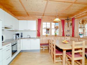 eine Küche mit weißen Schränken und einem Holztisch in der Unterkunft Chalet in Schwendau - A 241.003 in Schwendau