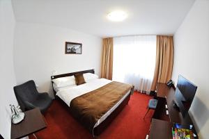 a hotel room with a bed and a desk at Alexandra Šport Hotel in Púchov +19 photos
