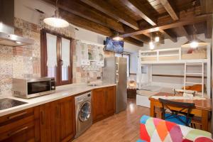 a kitchen with a refrigerator and a stove top oven at Apartamentos El Aramo Asturias in Pola de Lena