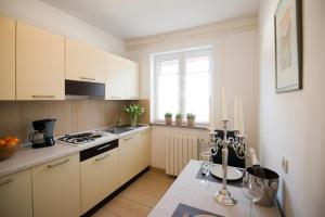 a kitchen with white cabinets and a stove top oven at Apartments Sandra in Poreč