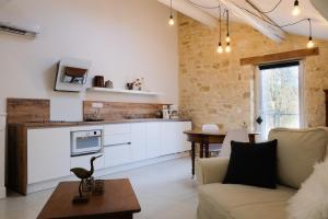 a kitchen and living room with a couch and a table at le gîte de Montagnac in La Roque-sur-Cèze