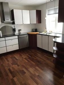 a kitchen with white cabinets and a wooden floor at Hotel Nuuk - Apartment Nanoq in Nuuk