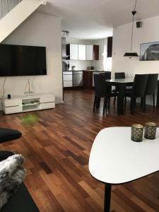 a living room with a white table and a tv at Hotel Nuuk - Apartment Nanoq in Nuuk