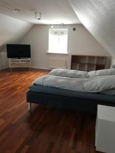 a bedroom with a bed and a flat screen tv at Hotel Nuuk - Apartment Nanoq in Nuuk