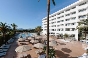 a hotel with a pool and tables and umbrellas at Bordoy Alcudia Bay - Adults Only in Port d'Alcudia +40 photos