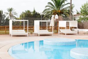 a pool with two chairs and a table and a umbrella at Aluasoul Alcudia Bay in Port d'Alcudia