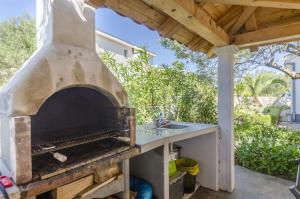 an outdoor pizza oven with a sink in a patio at Apartments Marija in Ražanj