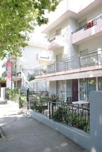 a building with tables and chairs in front of it at Hotel Midi in Riccione