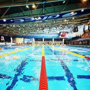 a large swimming pool with a red swim lane at Hotel Fama in Hódmezővásárhely