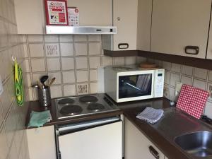 
a kitchen with a stove and a microwave at Studio Oostende Budget in Ostend
