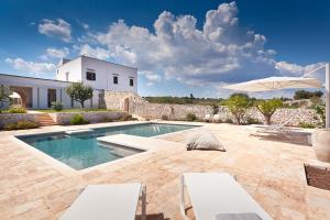 a villa with a swimming pool and a house at Masserie Maresca in Ostuni