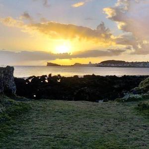 a sunset over a body of water with the sun setting at Aparthotel Barracuda in Ponta Delgada