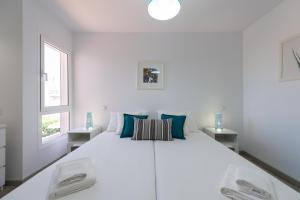 - une chambre blanche avec un grand lit blanc et 2 fenêtres dans l'établissement Bungalow tipo duplex en Sonneland, Maspalomas, à Maspalomas 20 autres photos