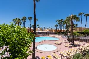 une piscine avec des chaises longues et un complexe hôtelier dans l'établissement Bungalow tipo duplex en Sonneland, Maspalomas, à Maspalomas