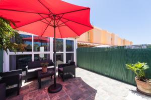 - un parasol rouge assis au-dessus d'une terrasse dans l'établissement Bungalow tipo duplex en Sonneland, Maspalomas, à Maspalomas