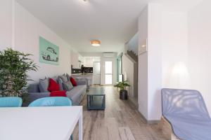 - un salon avec un canapé gris et des fauteuils bleus dans l'établissement Bungalow tipo duplex en Sonneland, Maspalomas, à Maspalomas