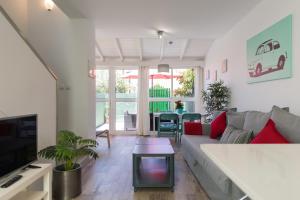 un salon avec un canapé et une télévision dans l'établissement Bungalow tipo duplex en Sonneland, Maspalomas, à Maspalomas