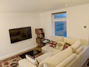 a living room with a couch and a flat screen tv at Modern 2 Bedroom Flat with private outdoor terrace in London