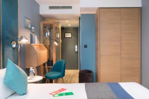 a hotel room with a bed and a chair at Hôtel Sanso by HappyCulture in Paris