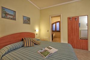 Un dormitorio con una cama con un libro encima. en San Rocco Relais, en Soiano del Lago 43 fotos más