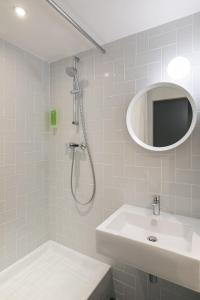 a bathroom with a shower and a sink and a mirror at Hôtel Sanso by HappyCulture in Paris