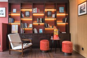 a room with a book shelf with a table and chairs at Hôtel Sanso by HappyCulture in Paris