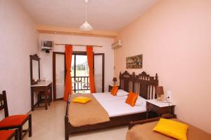 a bedroom with two beds and a desk and a window at Maria Studios in Neo Klima
