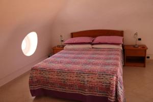 a bedroom with a large bed with two pink pillows at Le Case dei Pescatori - Villa Domitilla in Ponza