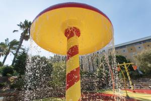 a yellow and red pole with water in a fountain at Alfagar Alto da Colina in Albufeira
