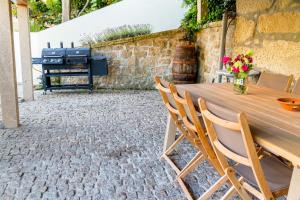 - une table et des chaises sur une terrasse avec barbecue dans l'établissement Casa da Oliveira, à Mondim de Basto
