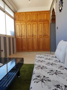 Habitación con cama y armario de madera. en App Khouribga, en Khouribga