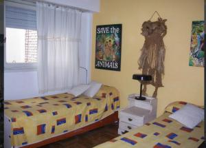 1 dormitorio con 2 camas y un cartel en la pared en Departamento en Varese frente al mar con terraza y cochera en Mar del Plata
