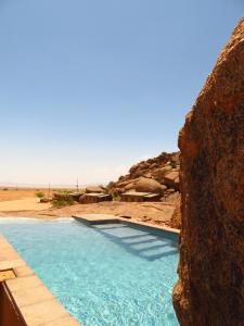 ein Schwimmbad mitten in der Wüste in der Unterkunft Soft Adventure Camp in Solitaire