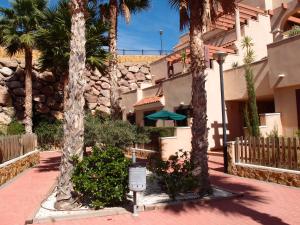 un patio con palmeras y un edificio en Tranquil apartment close to pool, en Águilas