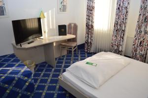 1 dormitorio con 1 cama, escritorio y ordenador en booking Residenz en Coburg
