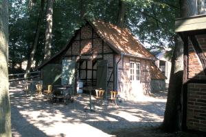 a small house with chairs and a grill in front of it at Glockenhof Studtmann in Amelinghausen