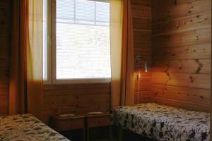 een slaapkamer met 2 bedden en een raam bij Ounasvaara Sport Cottages in Rovaniemi