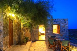 a patio with a table and chairs and a tree at Armonia by Grispos Villas in Schinoussa
