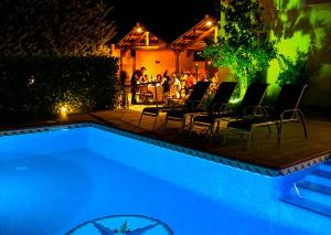 a swimming pool at night with chairs and a table at Ca l'Americano in Llacuna