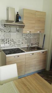 a kitchen with a sink and a tile wall at Residence Adriatico in Lido Adriano
